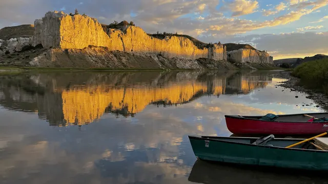 Canoes beside the Missouri River and cliffs in an archive photograph