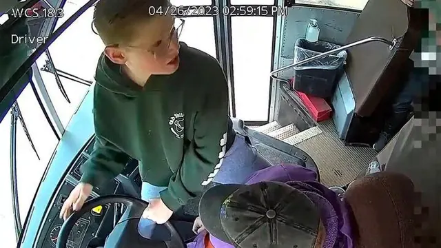 Bus-camera footage shows Dillon Reeves at the steering wheel beside the driver.