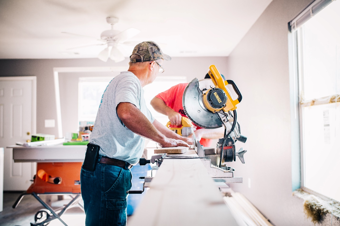 A person using a miter saw during an indoor renovation